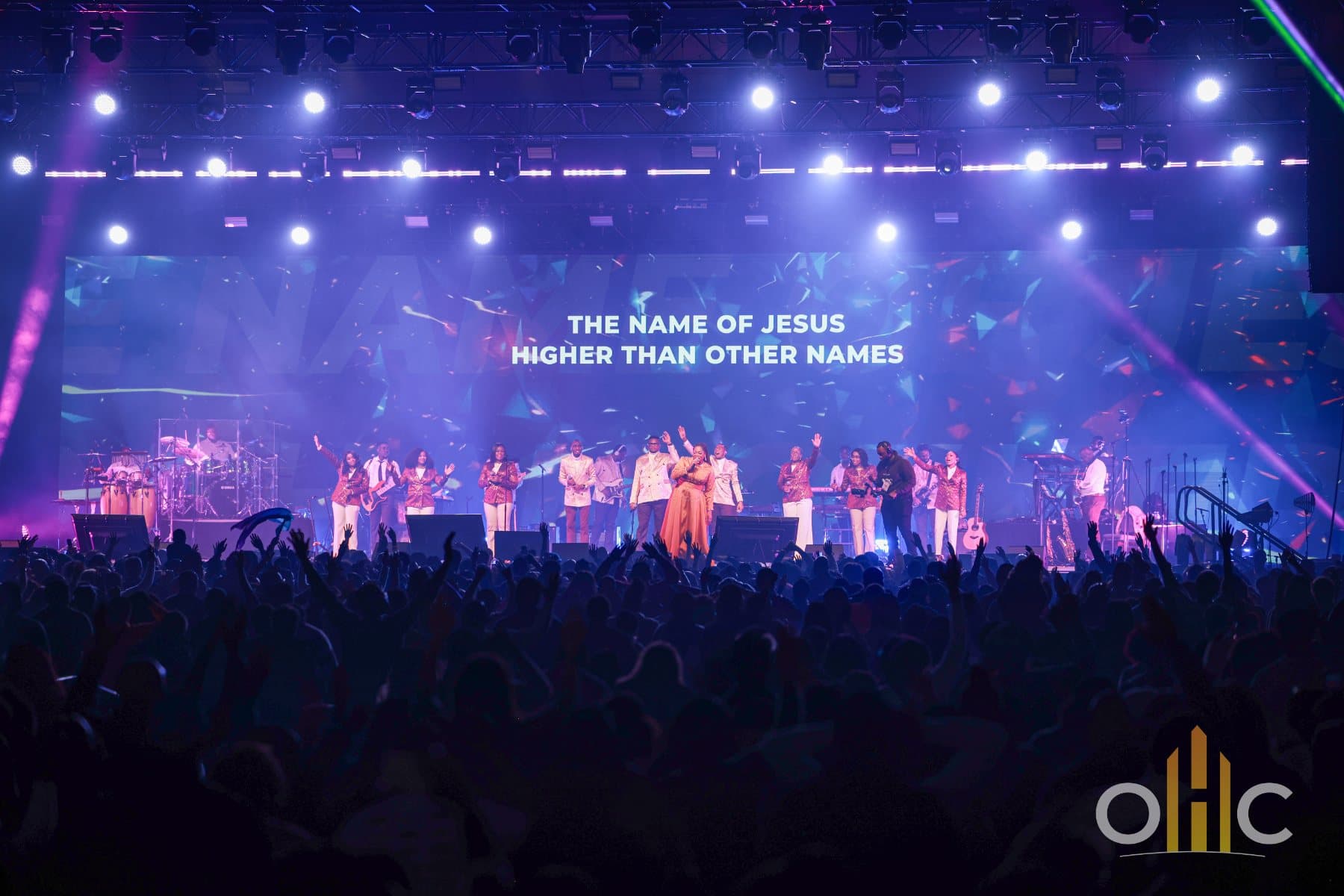 Les NCA Psalmists dirigent la louange sur scène à Open Heavens Calgary 2024, pendant que la foule lève les mains